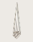 Købn Crema Towel with stripes and raw edge fringing hanging on a hook