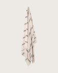 Købn Ecru Towel with stripes and raw edge fringing hanging on a hook