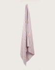 Købn Lilac Towel with stripes and raw edge fringing hanging on a hook