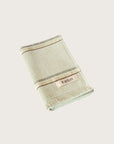 Folded mint hand towel with stripes and 'kobn' branding on a light beige background