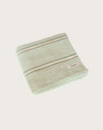 Light Green towel with multi coloured stripe folded on a white background