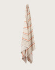 Købn Sand Towel with stripes and raw edge fringing hanging on a hook