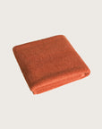 Købn Tamarillo Bathmat folded with a plush pile chunky cotton weave. Sustainably made in Turkey.