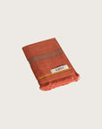Købn Tamarillo Hand Towel featuring raw edge fringing folded