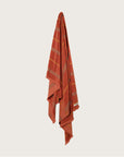 Købn Tamarillo Towel with stripes and raw edge fringing hanging on a hook