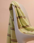Elevated Citrus towel by kobn with brown stripes on an original Casala Dining Chair