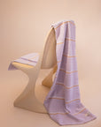 Luxury cotton towel by kobn in Lilac with a stripe draped on an original Casala Dining Chair