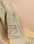 Kobn Matcha towel draped on a chair after a swim