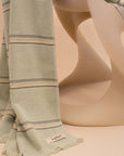 Kobn Matcha towel draped on a vintage Casella chair. Towel is lightweight and woven with premium cotton. Sustainably made in Turkey.