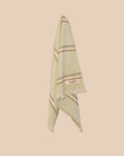 Light green hand towel with striped pattern and 'kebn' label on a beige background