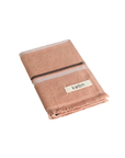 Folded Clay coloured hand towel with black and cream stripes and raw edge fringing.