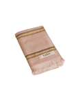Warm pink hand towel with a tonal brown stripe, fringing and 'kobn' label on a white background