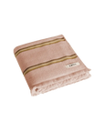Folded pink towel with tonal brown stripes and fringing on the ends, on a white background