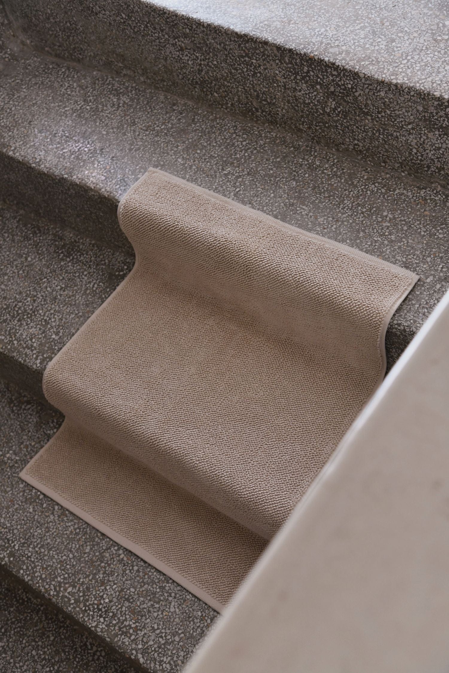 A chunky cotton bathmat placed flat 