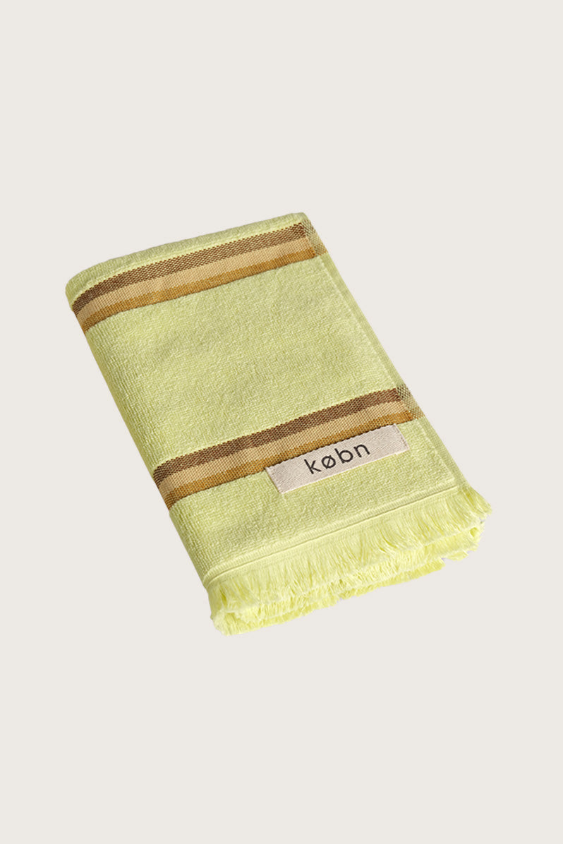 Købn Citrus Hand Towel featuring raw edge fringing folded 