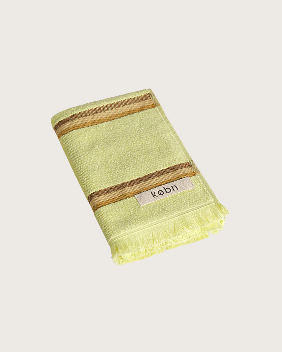 Købn Citrus Hand Towel featuring raw edge fringing folded 