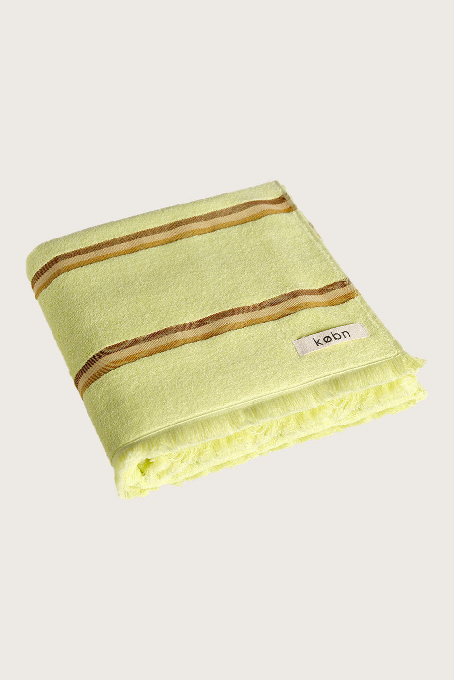 Købn Citrus Towel featuring raw edge fringing and stripes folded 