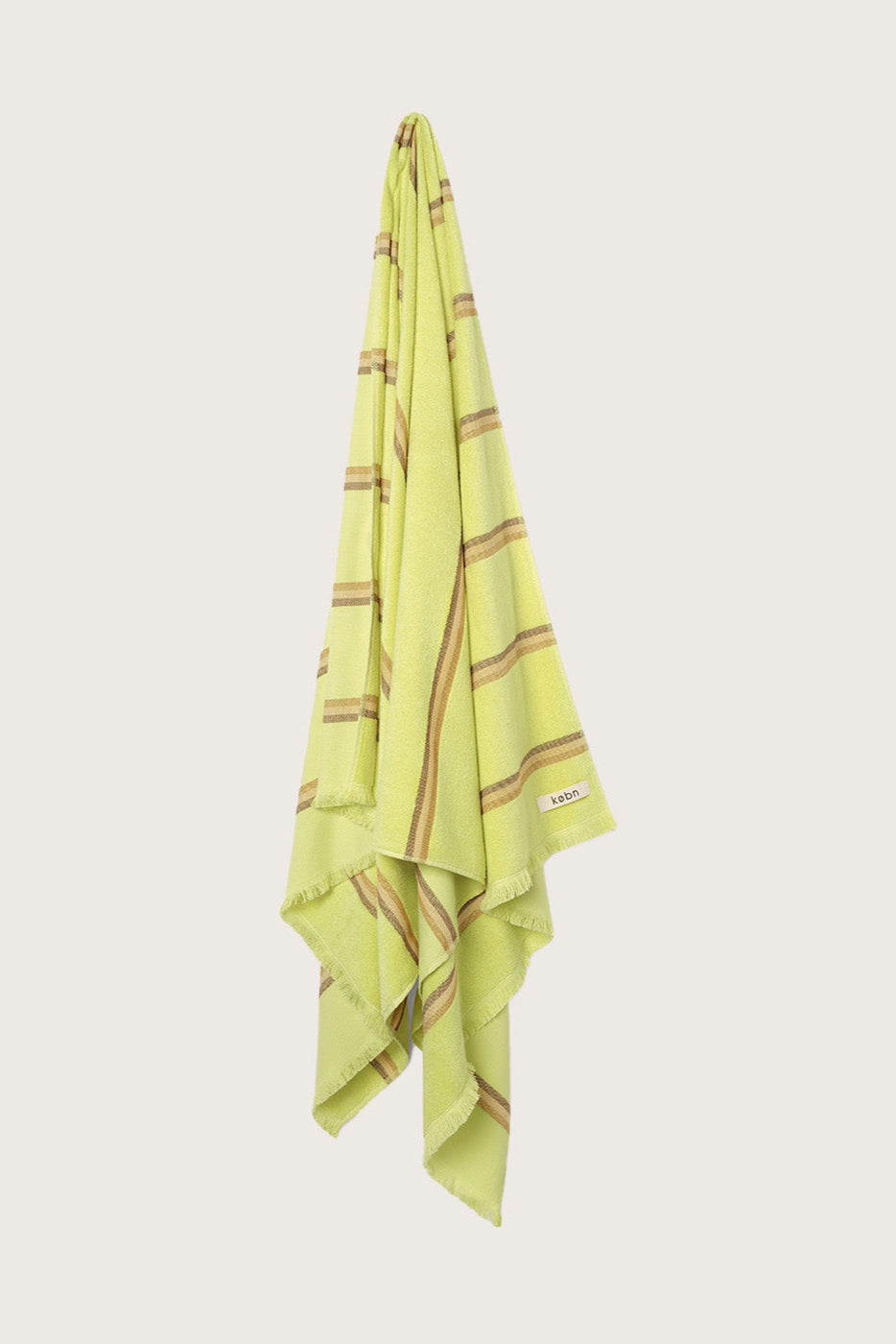 Købn Citrus Towel stripes and raw edge fringing hanging on a hook