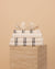 Kobn Crema Bathroom set includes towels, bathmat and handtowel, folded on a travertine plinth with a clam shell on top. 