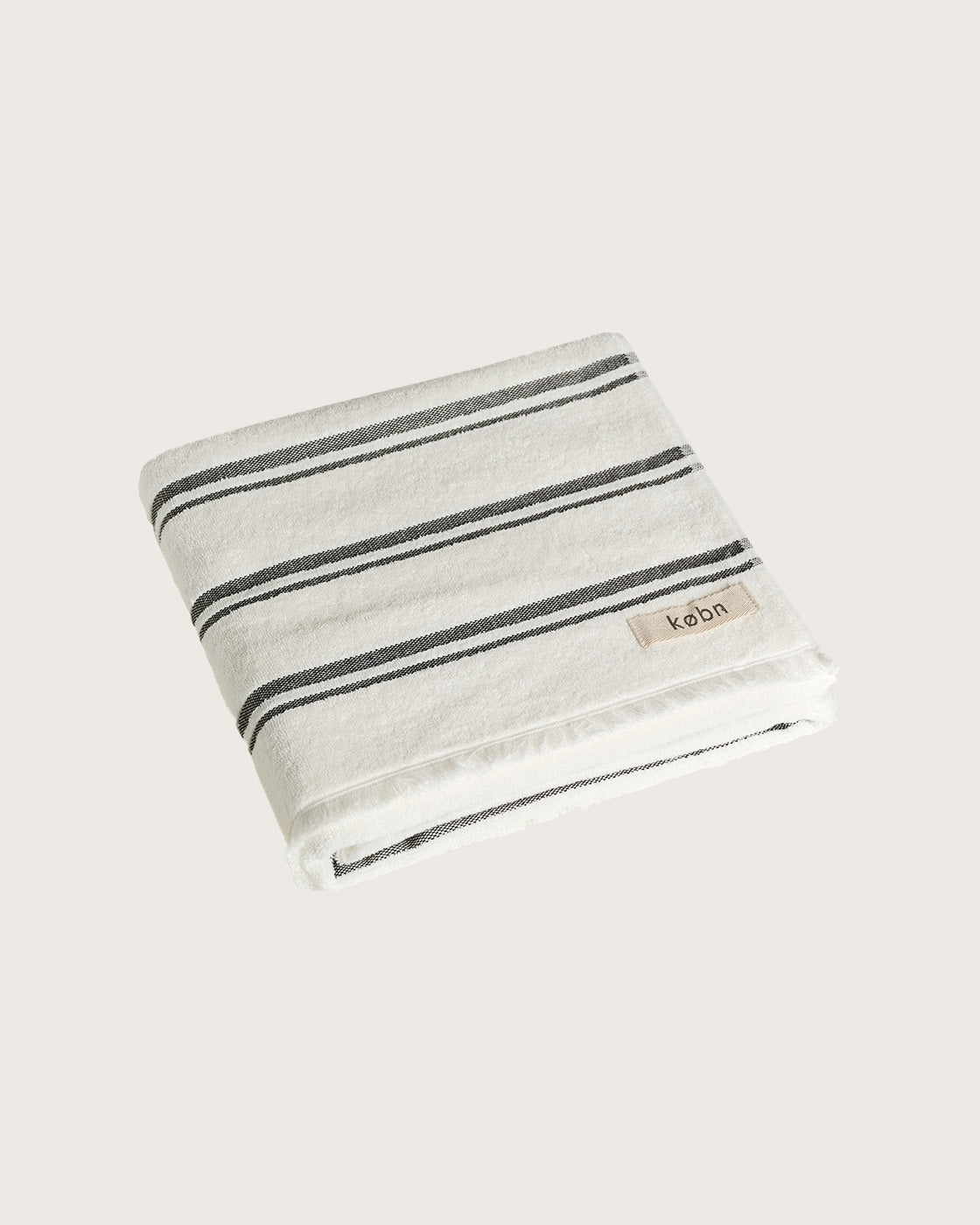 Købn Crema Towel featuring raw edge fringing folded 