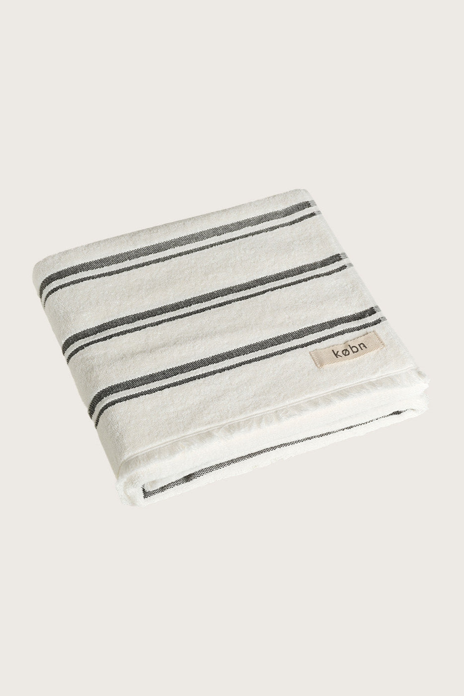 Købn Crema Towel featuring raw edge fringing folded 