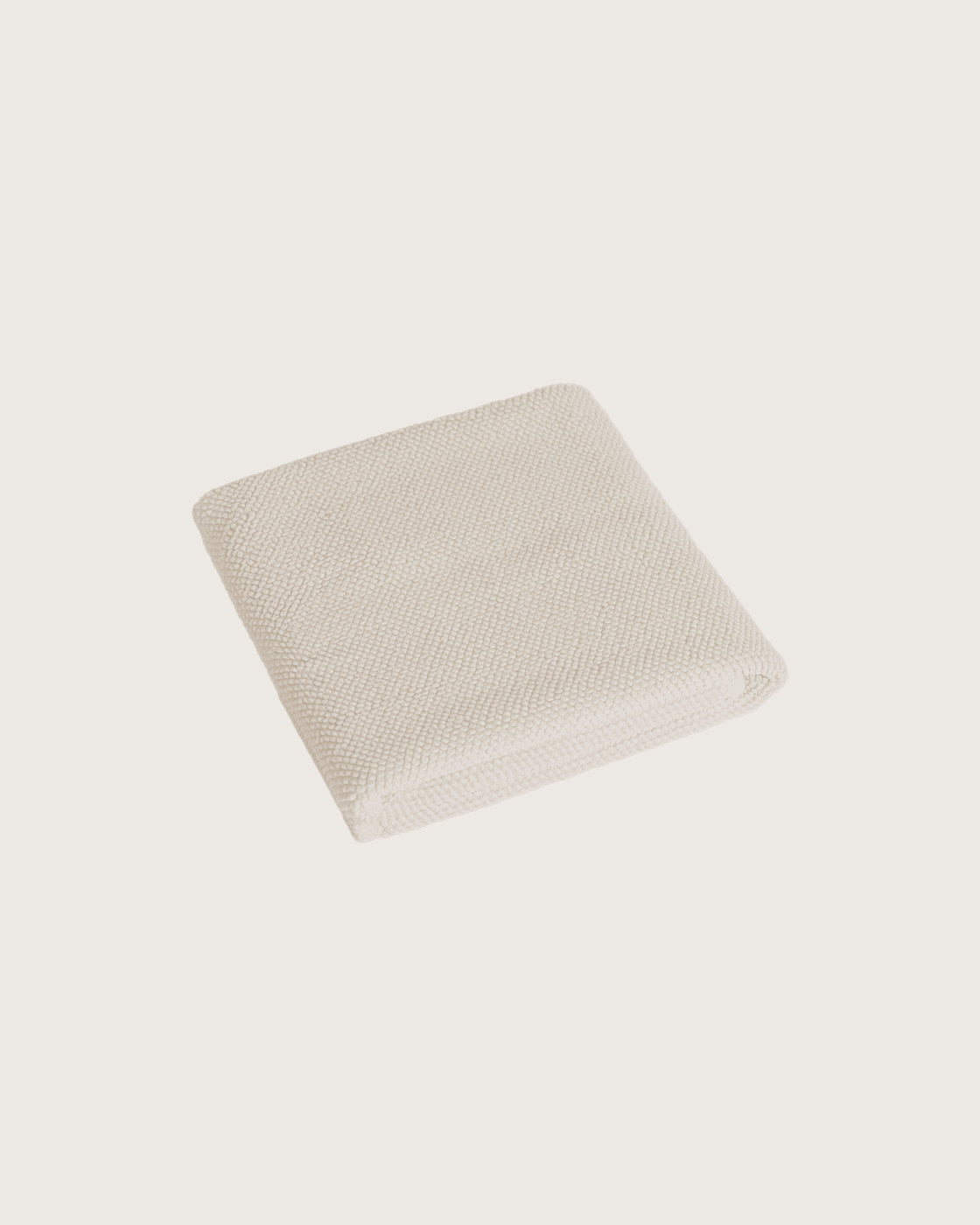 Købn Ecru Bathmat folded with a plush pile chunky cotton weave