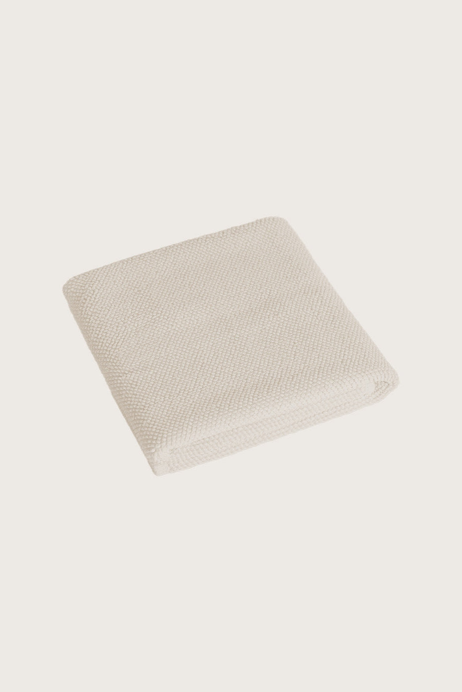 Købn Ecru Bathmat folded with a plush pile chunky cotton weave