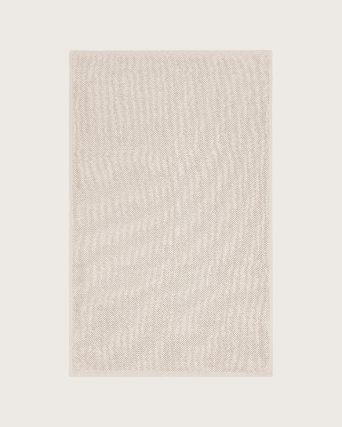 Købn Ecru Bathmat with a plush pile cotton weave layed flat