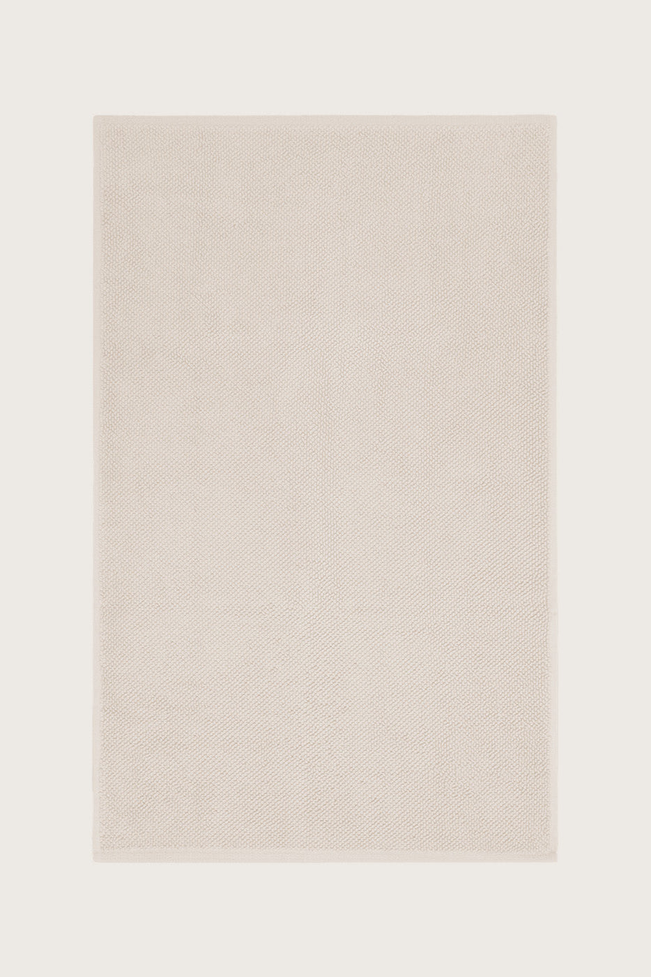 Købn Ecru Bathmat with a plush pile cotton weave layed flat