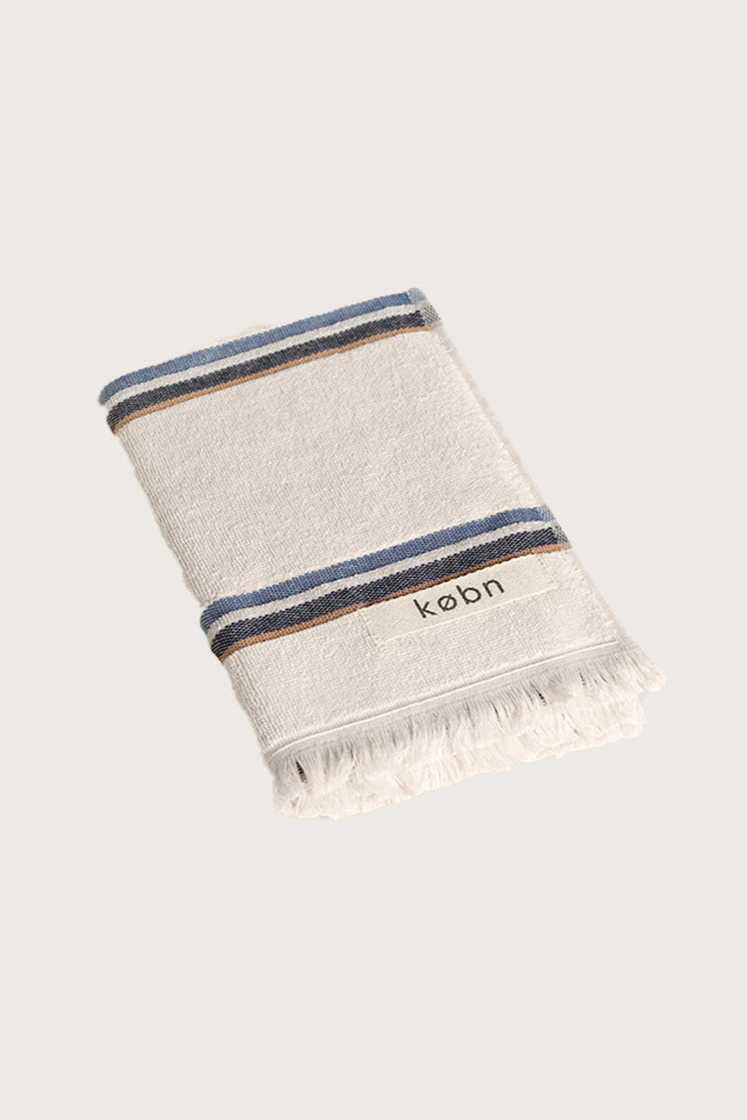 Købn Ecru Hand Towel featuring raw edge fringing folded 