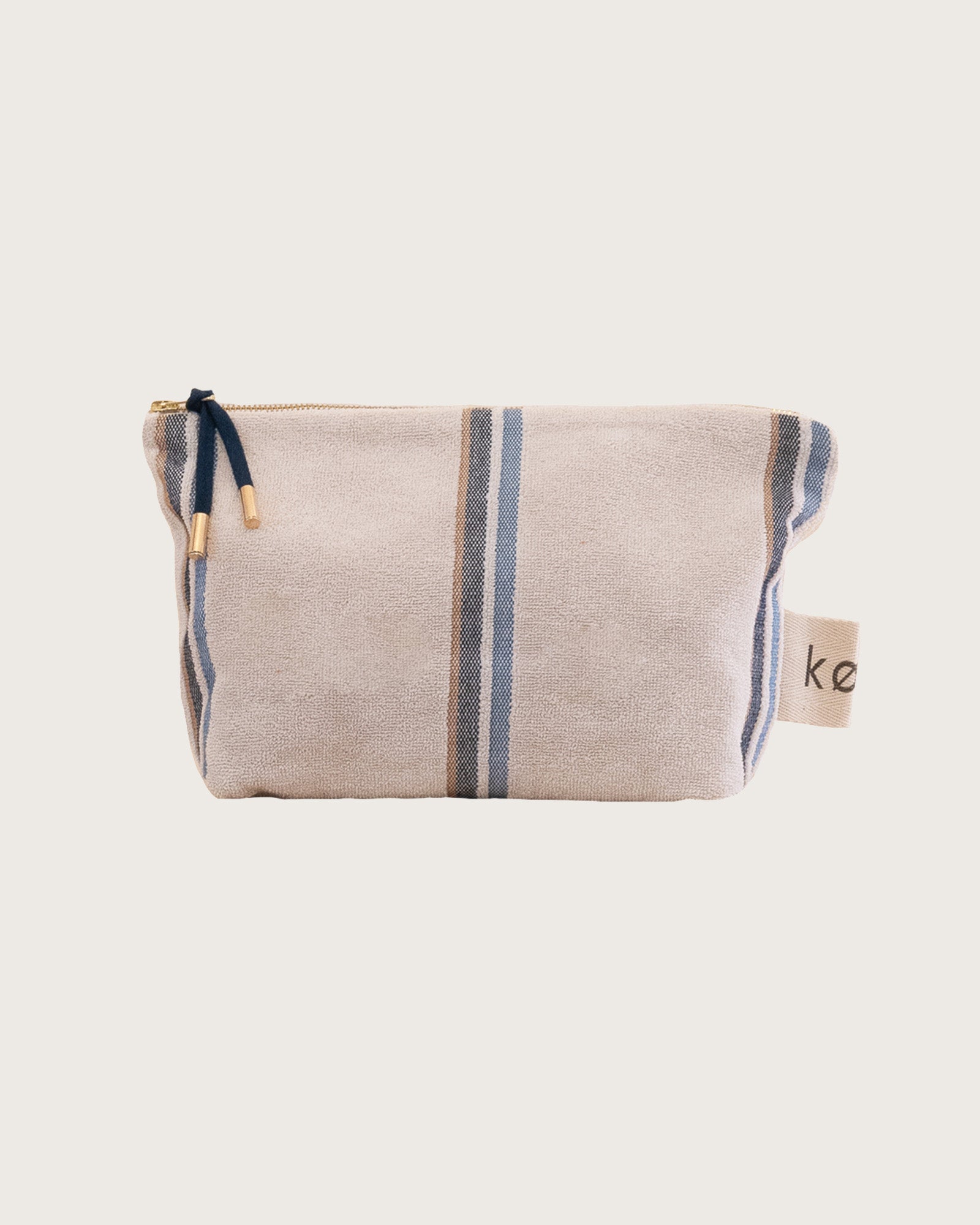 Kobn towelling pouch in Ecru with blue and tan stripes with a gold zip and feature zip pull in navy. 