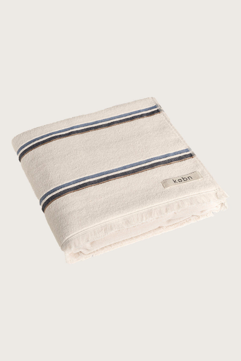 Købn Ecru Towel with blue and tan stripes featuring raw edge fringing folded 