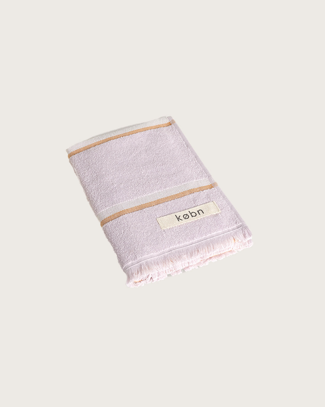 Købn Lilac Hand Towel featuring raw edge fringing folded 