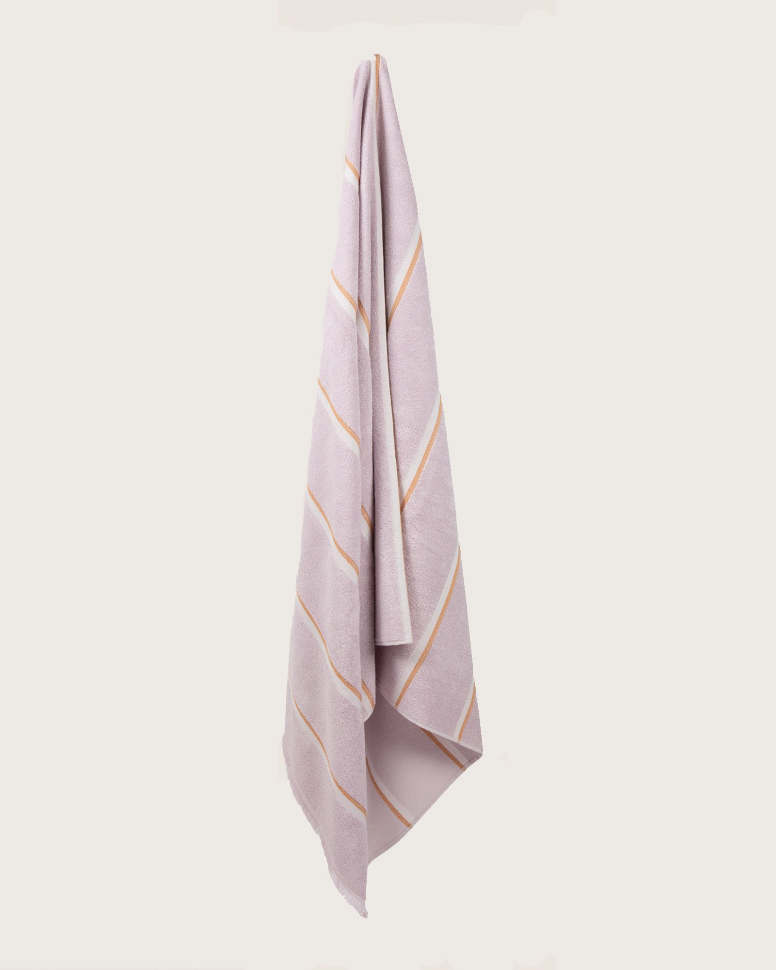 Købn Lilac Towel with stripes and raw edge fringing hanging on a hook