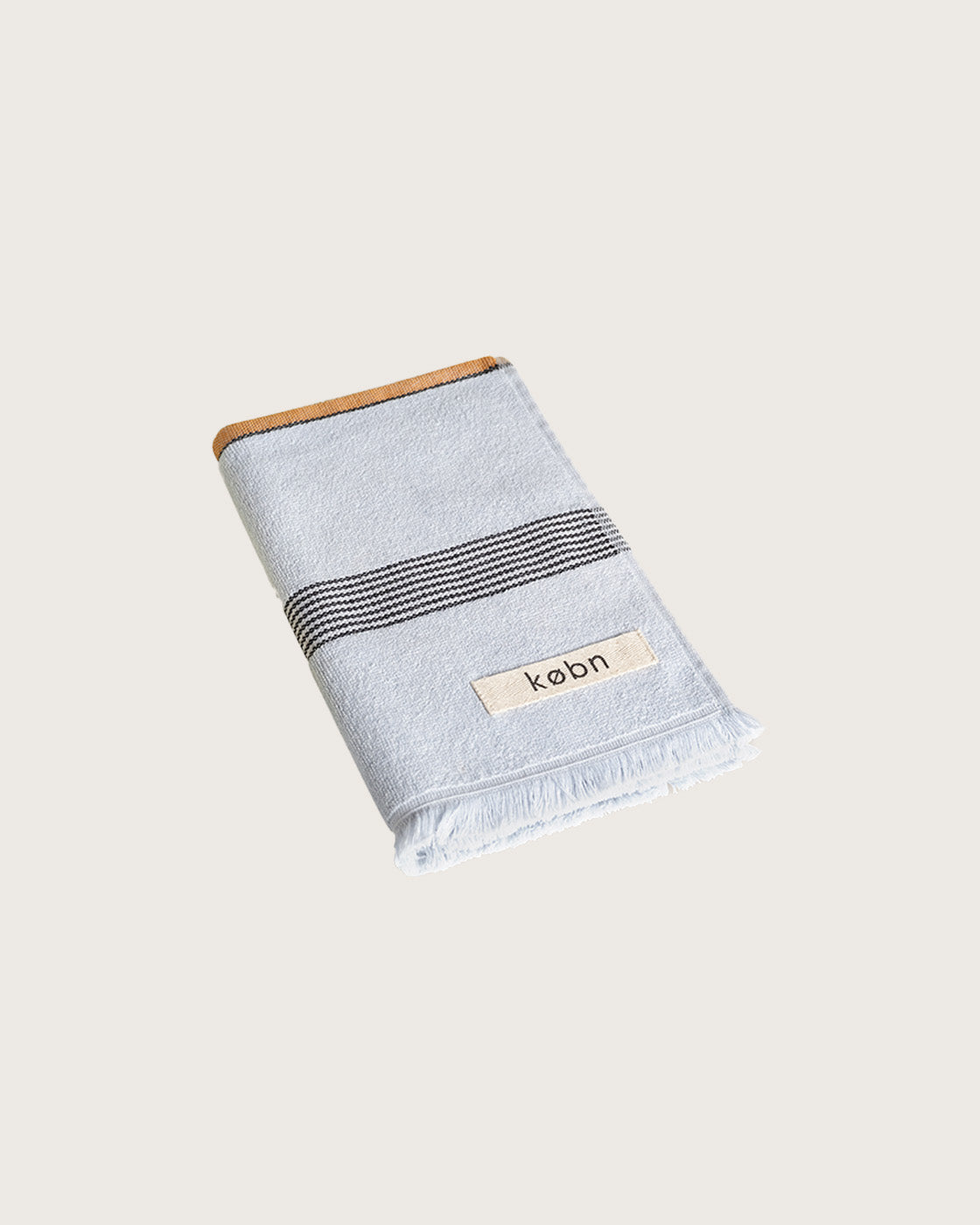 Købn Mist Hand Towel featuring raw edge fringing folded 