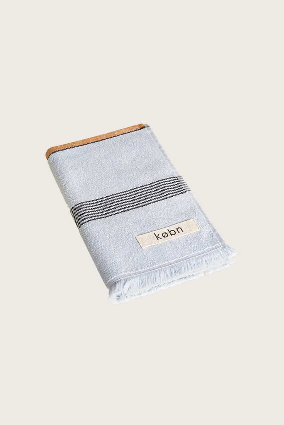 Købn Mist Hand Towel featuring raw edge fringing folded 
