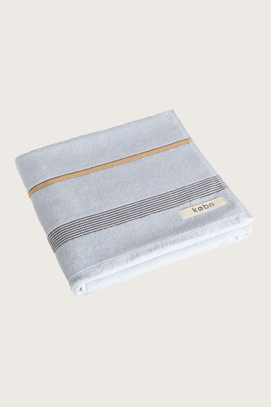 Købn Mist Beach or Bath Towel with black, cream and tan stripes folded.