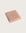 Folded pink bathmat on a light beige background