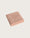 Folded pink bathmat on a light beige background
