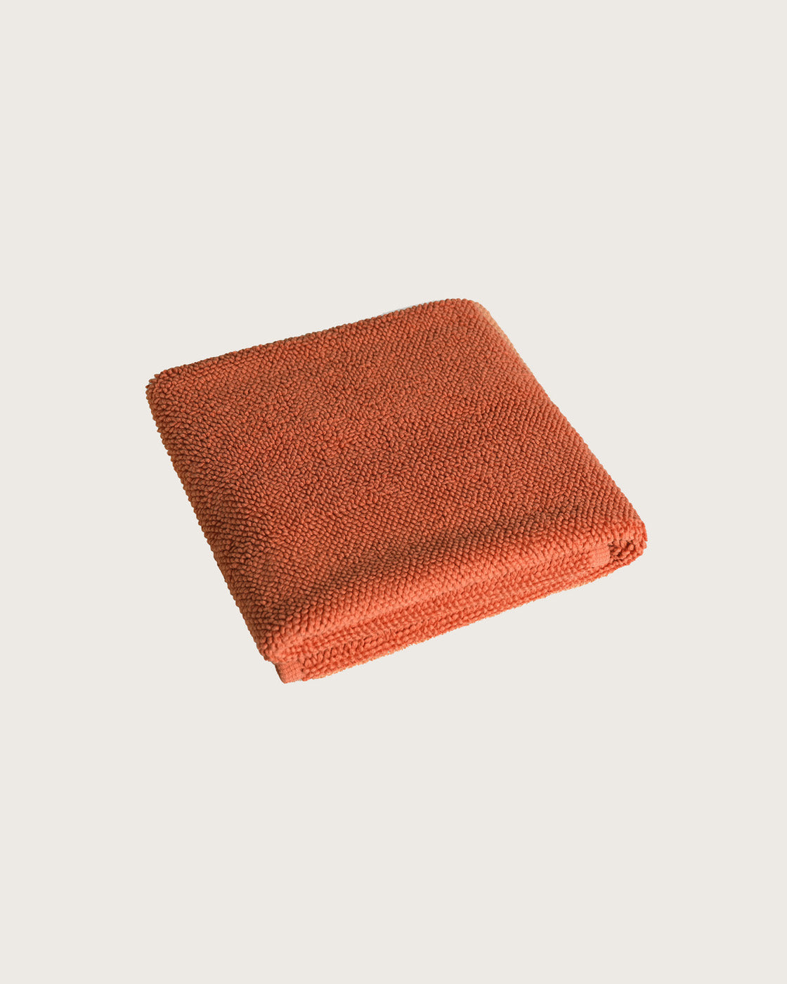Købn Tamarillo Bathmat folded with a plush pile chunky cotton weave. Sustainably made in Turkey. 