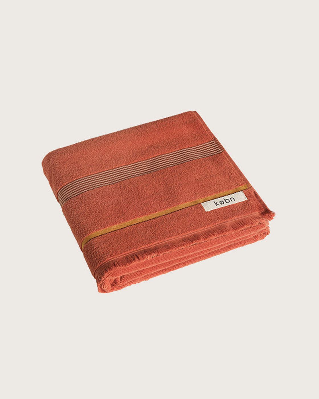 Købn Tamarillo Towel featuring raw edge fringing folded 