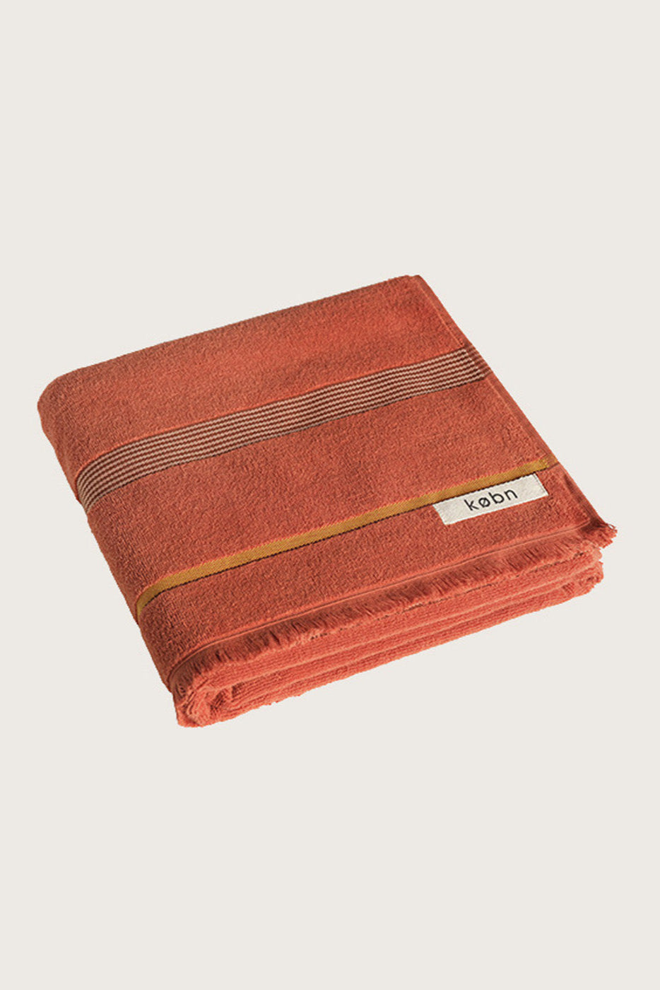 Købn Tamarillo Towel featuring raw edge fringing folded 
