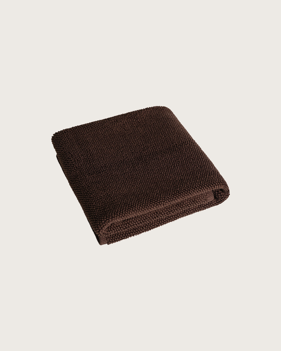 Købn Umber Bathmat folded with a plush pile chunky cotton weave