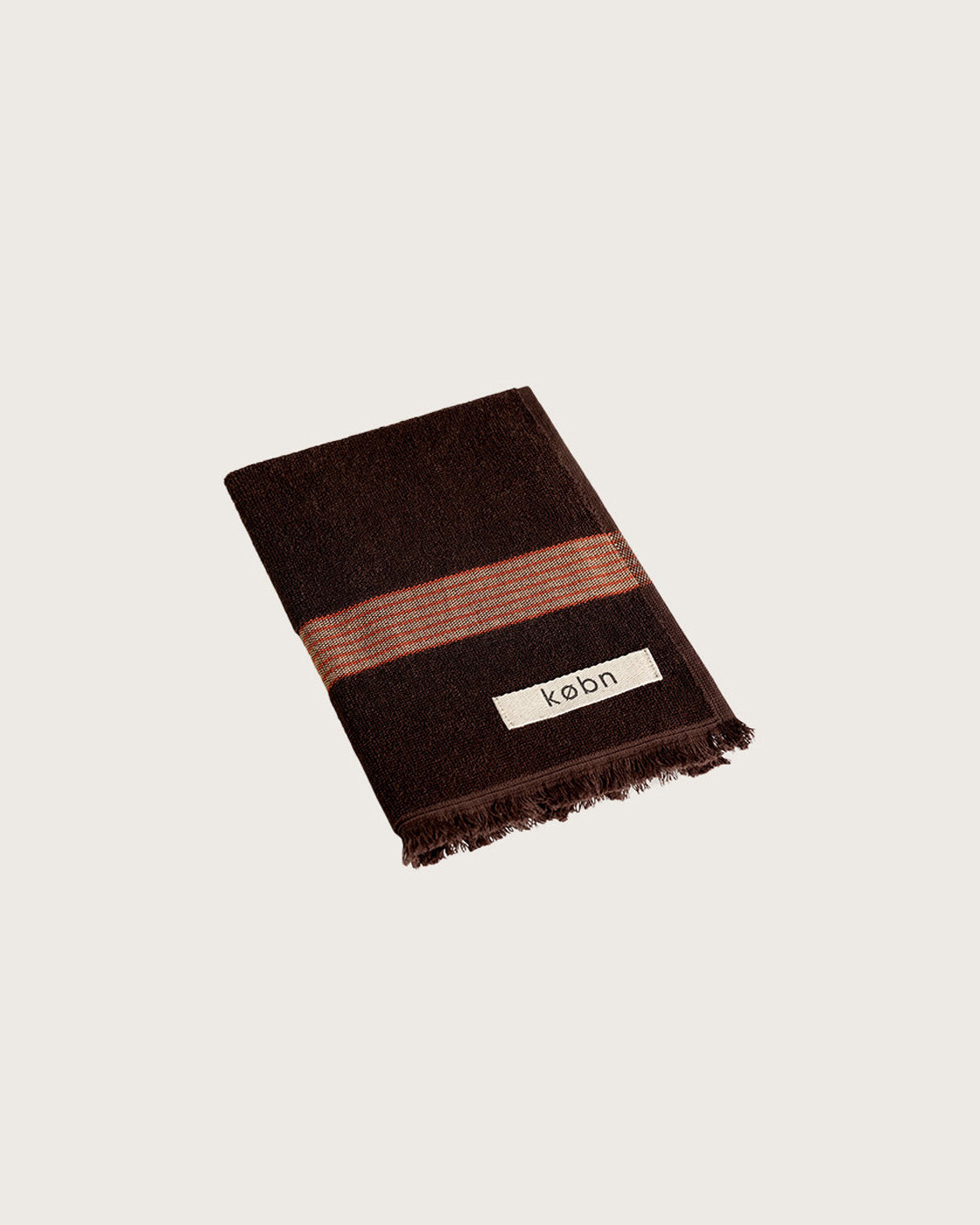 Købn Umber Hand Towel featuring raw edge fringing folded 