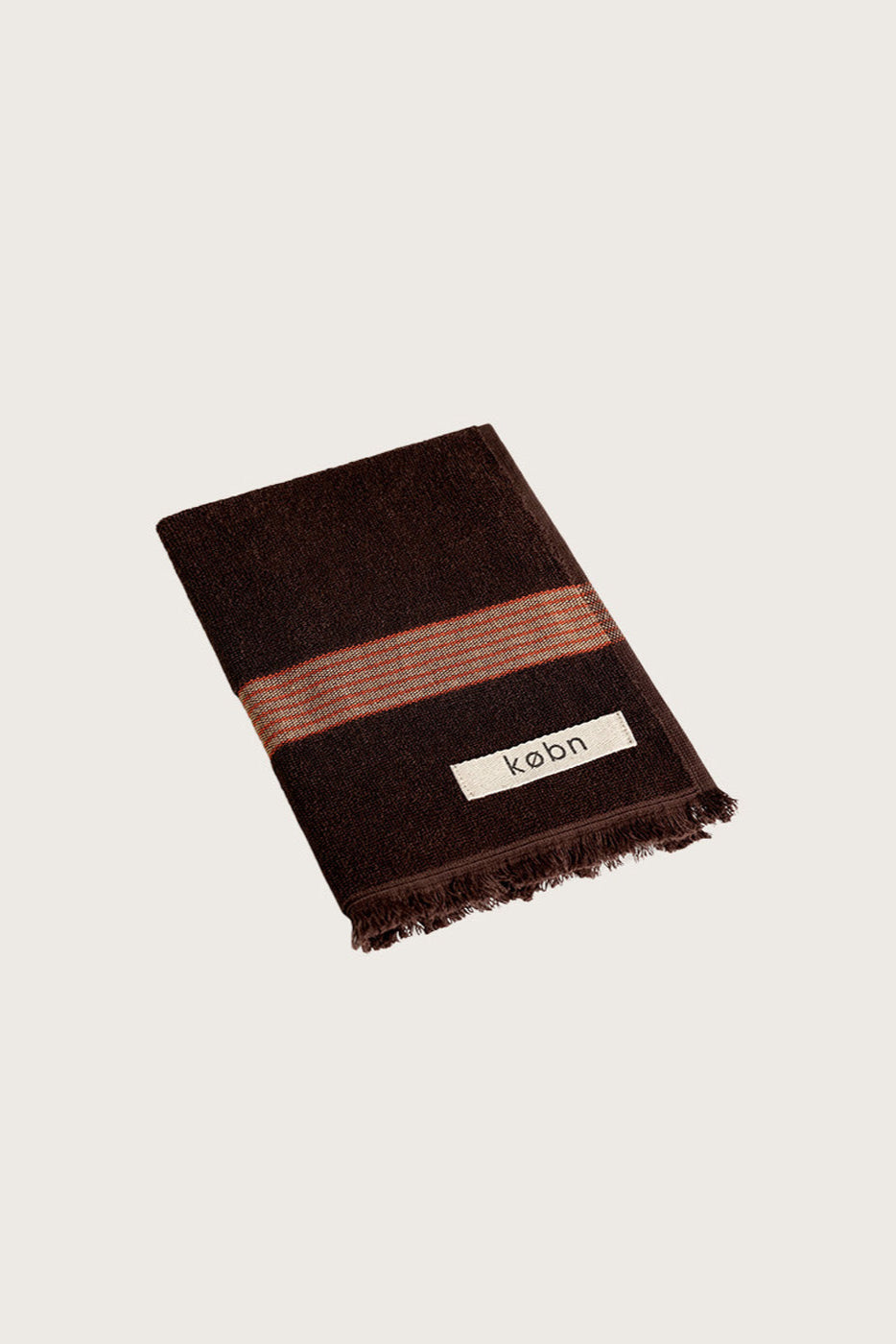 Købn Umber Hand Towel featuring raw edge fringing folded 