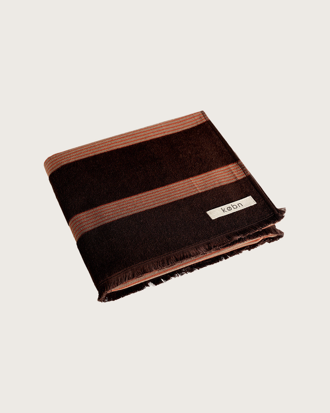 Købn Umber Towel featuring raw edge fringing folded 