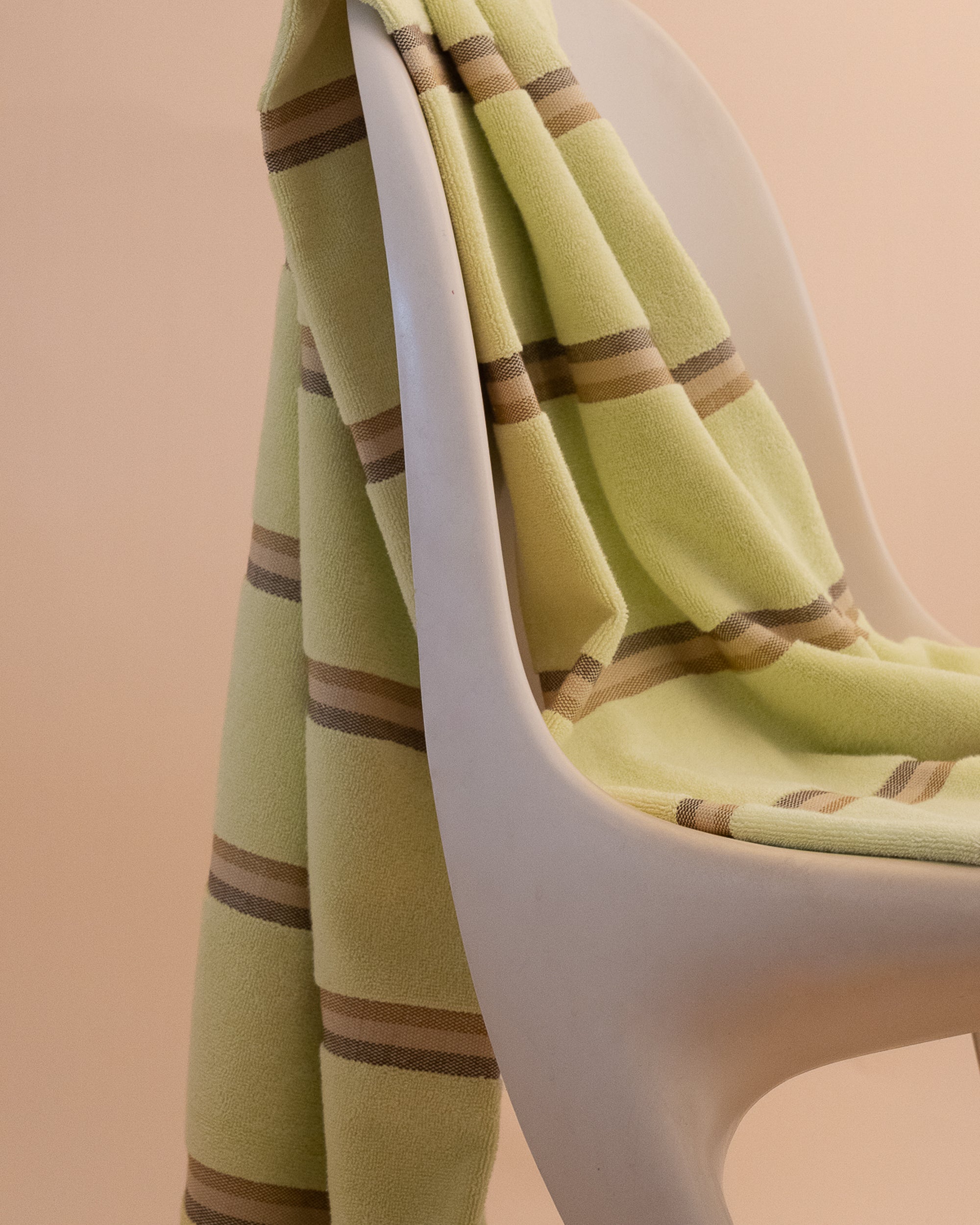Elevated Citrus towel  by kobn with brown stripes  on an original Casala Dining Chair