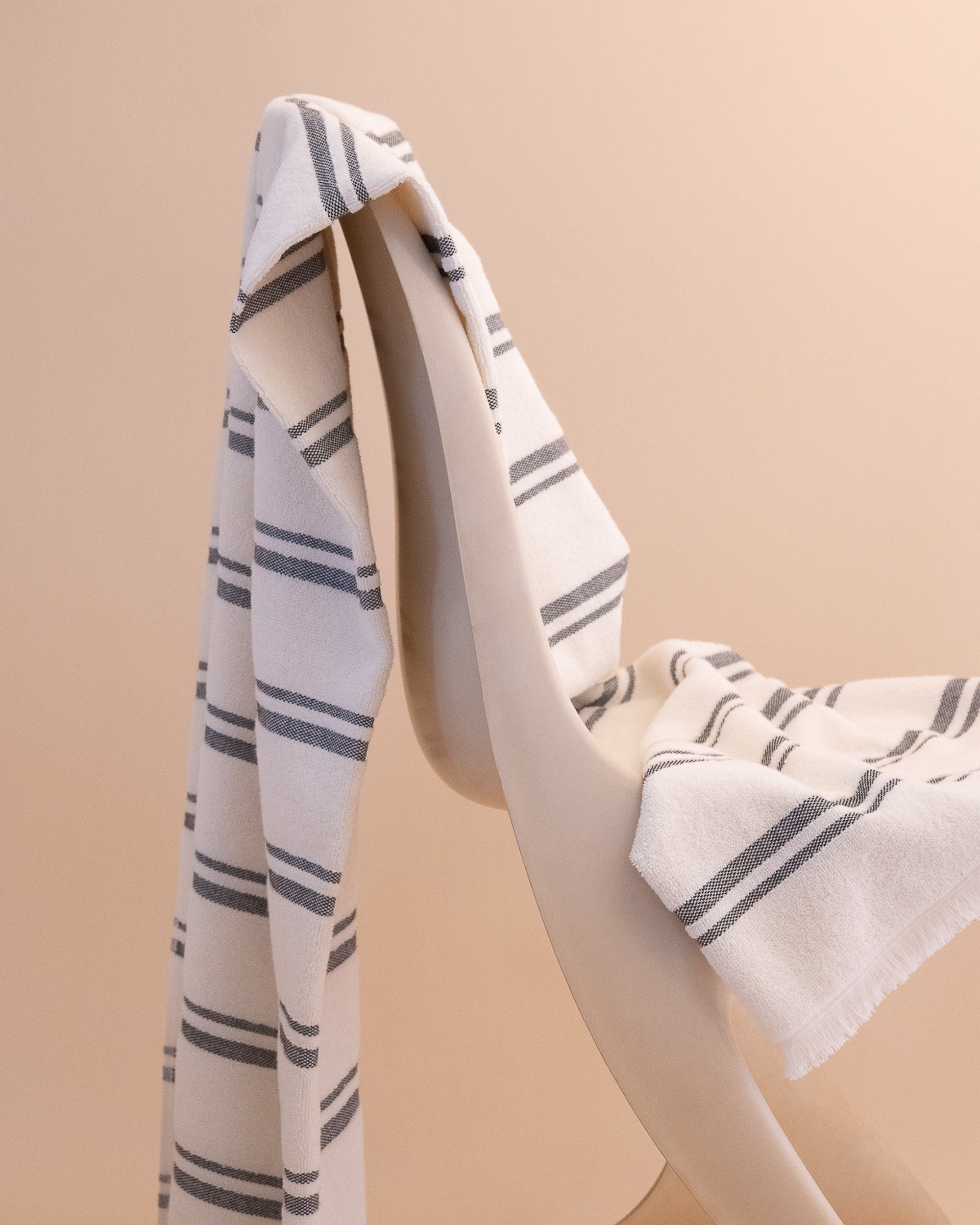 Kobn striped Crema towel draped on a chair