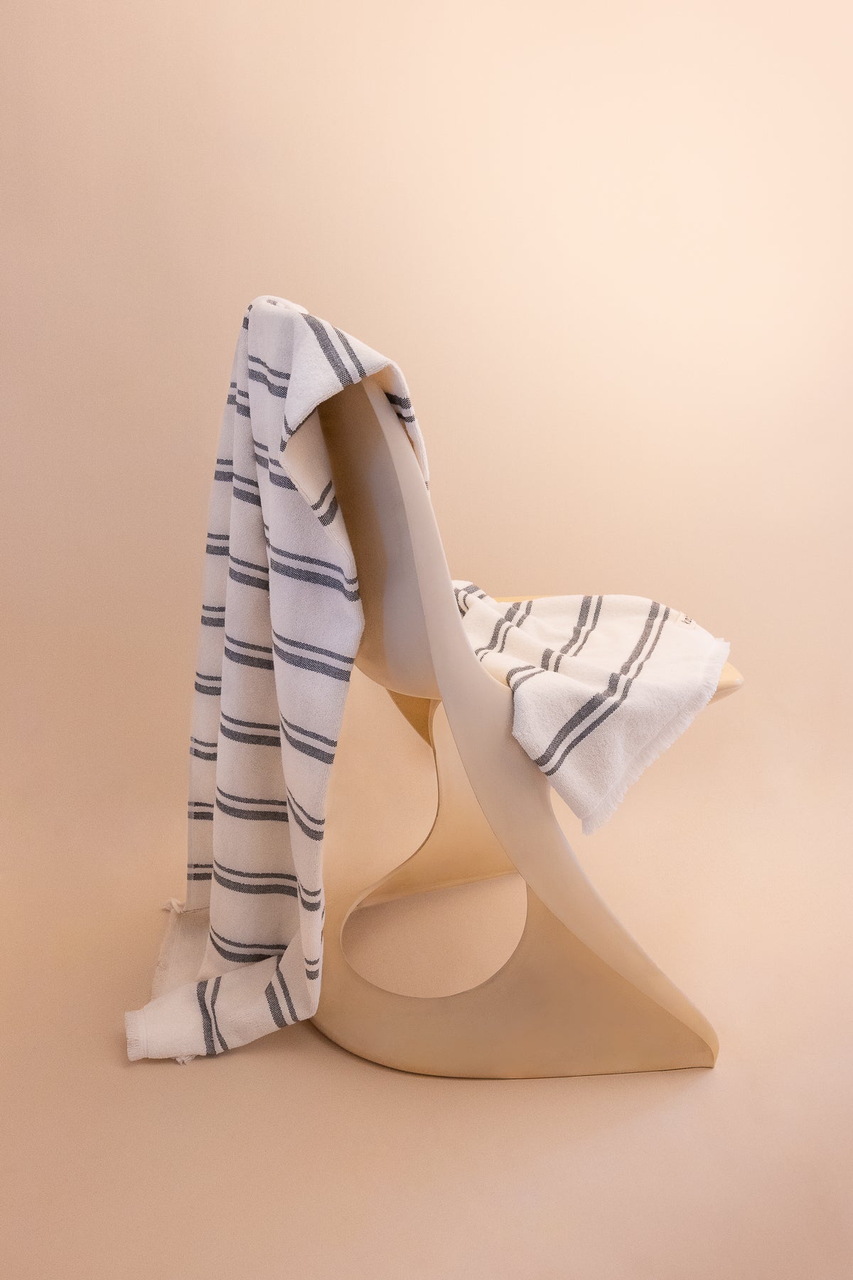 Kobn Crema striped towel draped on a chair