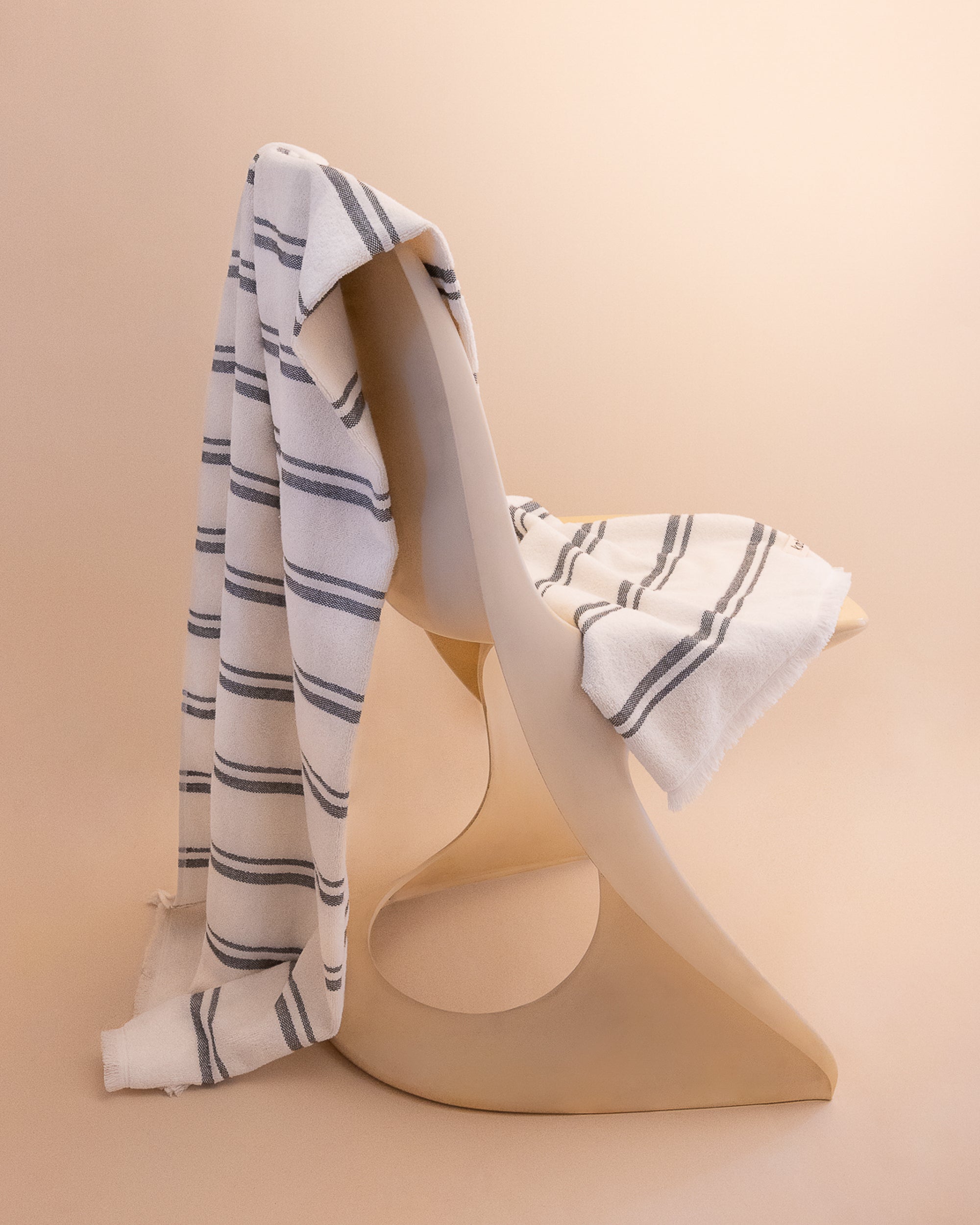 Kobn Crema striped towel draped on a chair